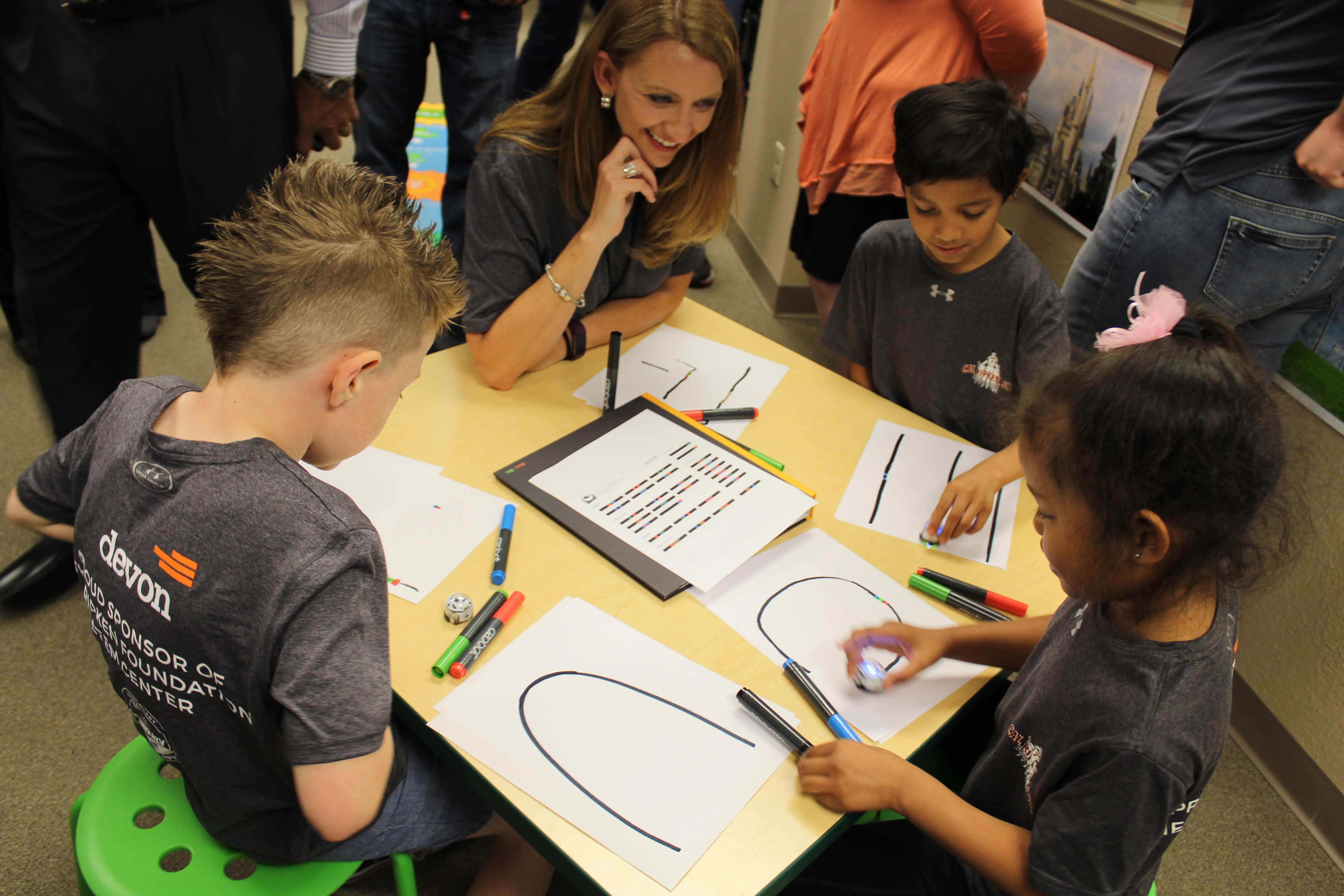 Students and their teacher exploring and learning with Ozobot.