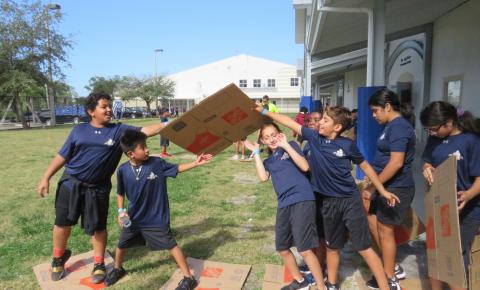 Campers working together to get across a "raging river" in a team-building activity